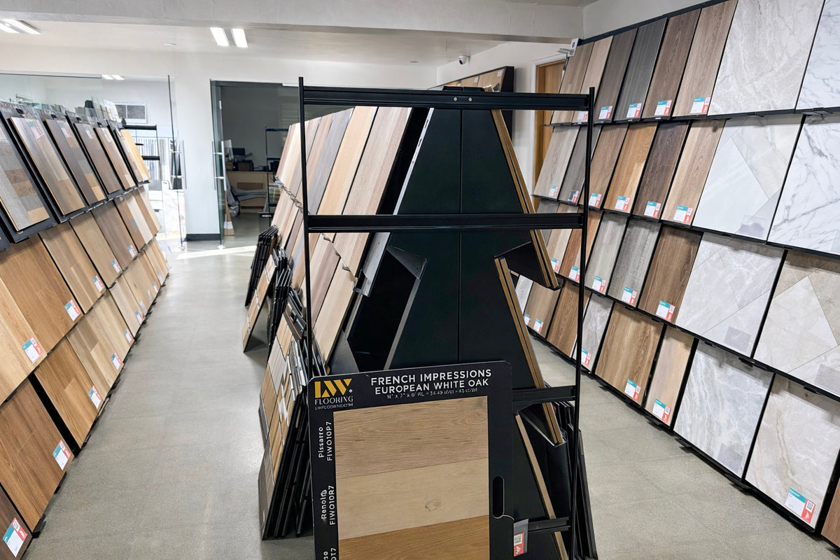 Display of wooden flooring samples in a showroom with 'LW Flooring' branding.