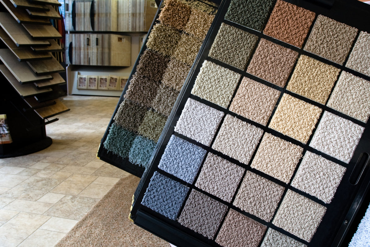 Carpet sample display with various color options in a showroom setting.