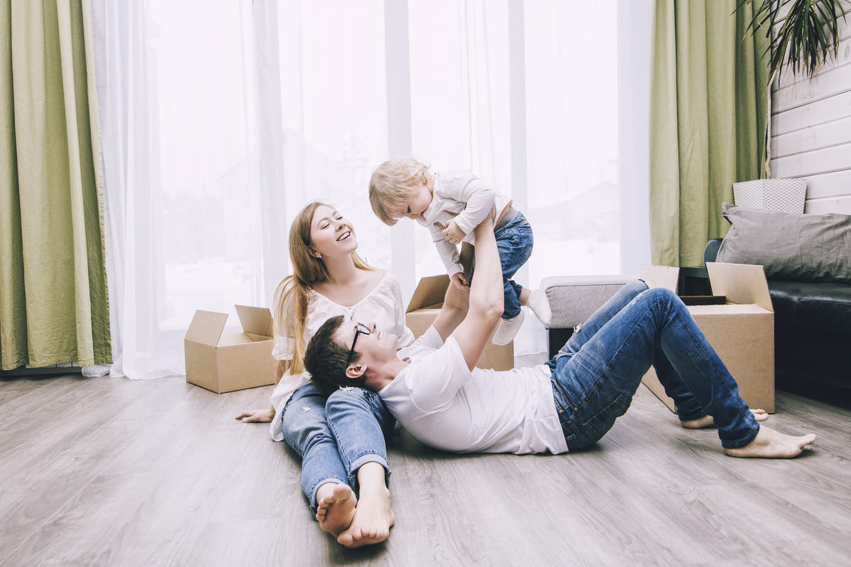 Family playing on the floor in a living room with boxes around